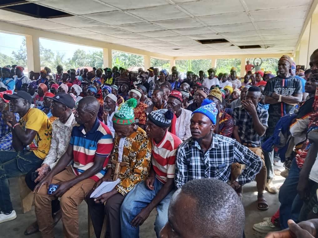 Community members gathered under a pavilion at a SANAD-facilitated town hall meeting in Sierra Leone